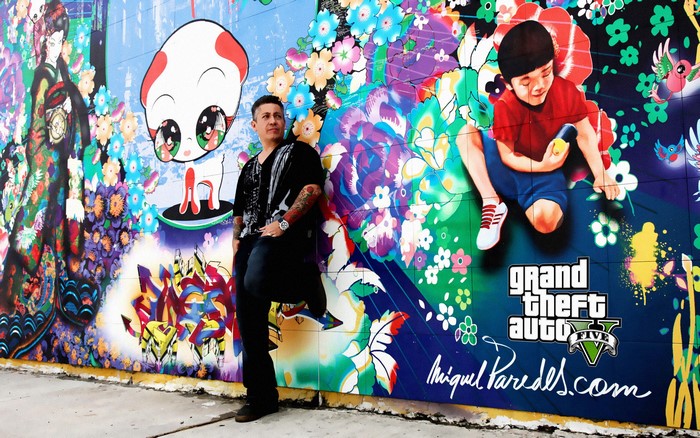 Man posing in front of Grand Theft Auto V mural