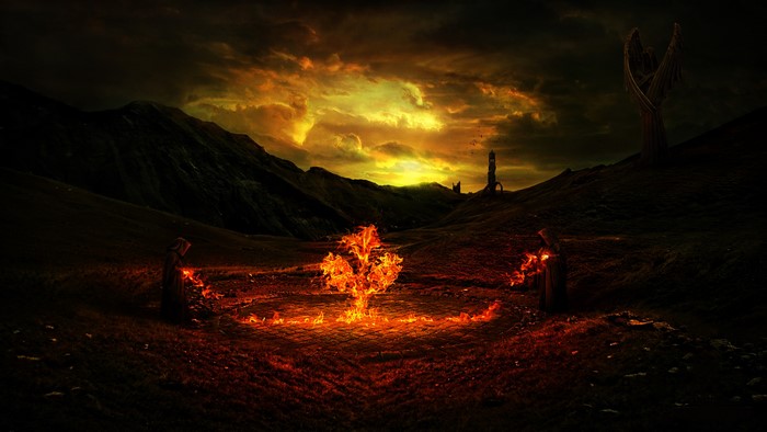 Two robed figures performing magic around a fiery tree