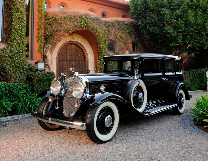 Black 1930 Cadillac Imperial Sedan in front of a building