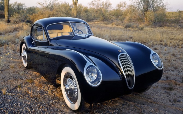 Black Jaguar XK120 Coupe in desert landscape