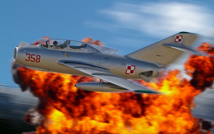 MiG-15 fighter jet flying through an explosion