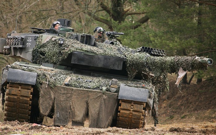 Leopard 2 tank with camouflage netting and crew