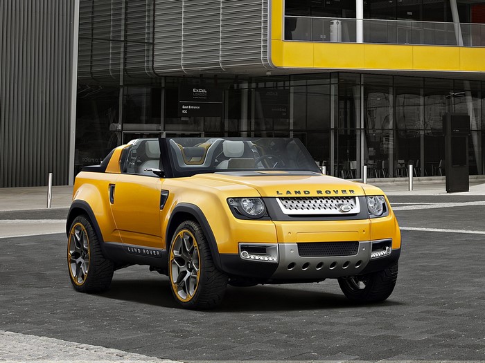 Yellow Land Rover concept car in front of modern building