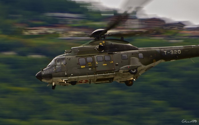 Military helicopter T-320 flying over green landscape