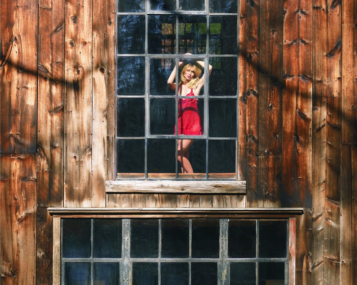 Florencia Salvioni in red lingerie behind a window