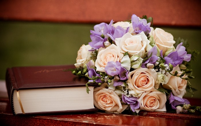 Bouquet of roses and freesia on a book