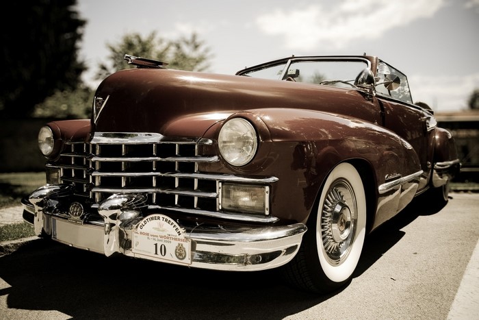 Vintage maroon Cadillac convertible with whitewall tires