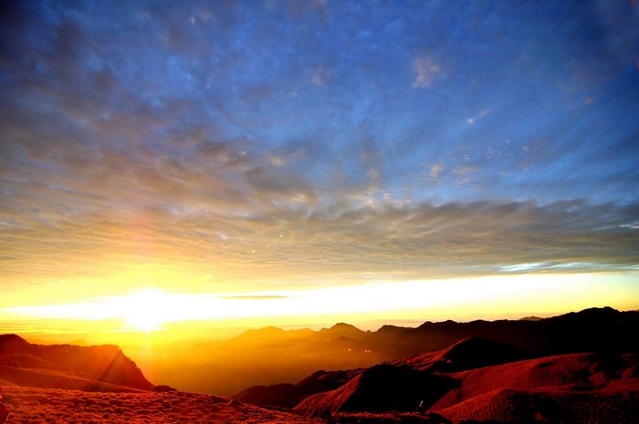 Sunrise over mountain range with dramatic clouds
