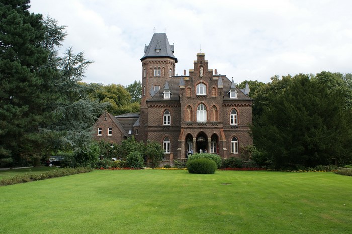 Brick castle with tower and green lawn