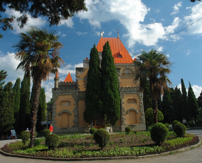 Palace-like building with orange roof and palm trees
