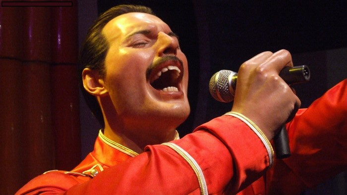 Freddie Mercury from Queen singing into a microphone