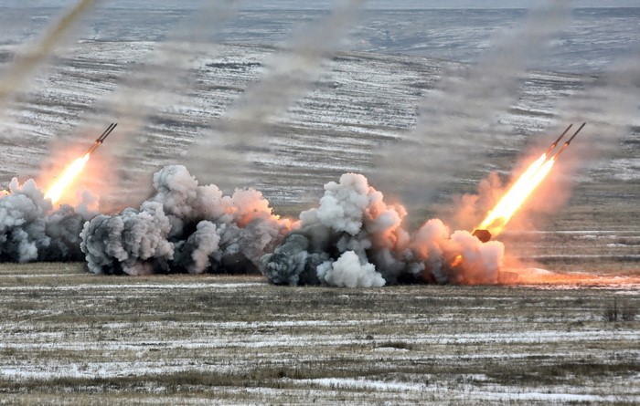 Rockets launching from a field with smoke