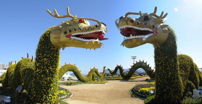 Two large floral dragon sculptures in a park