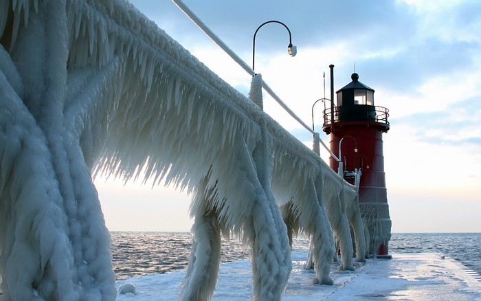 Frozen pier with lighthouse on a cloudy day