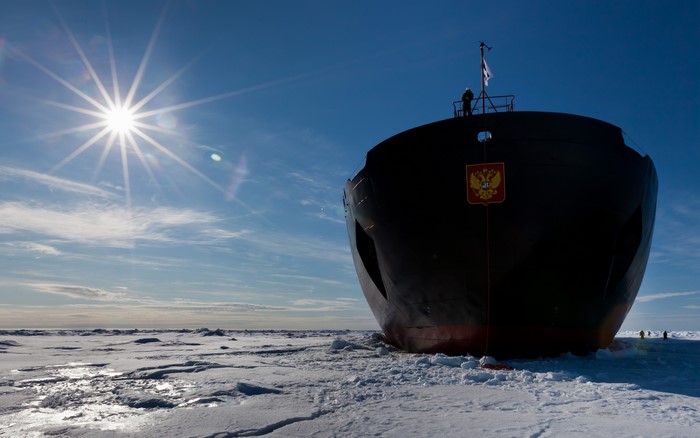 Icebreaker ship in frozen Arctic waters under the sun