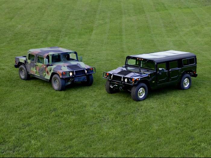 Two Humvees on a grassy field