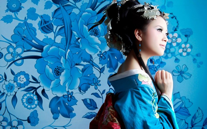Woman in traditional blue Asian dress with floral background