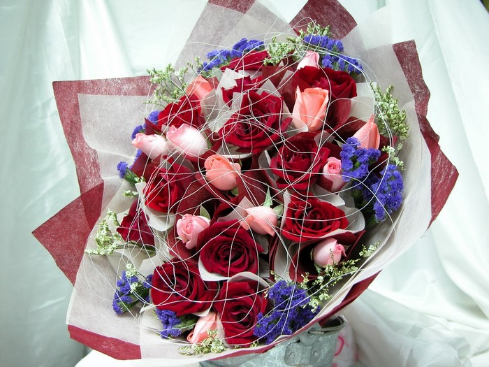 Bouquet of red and pink roses with blue flowers