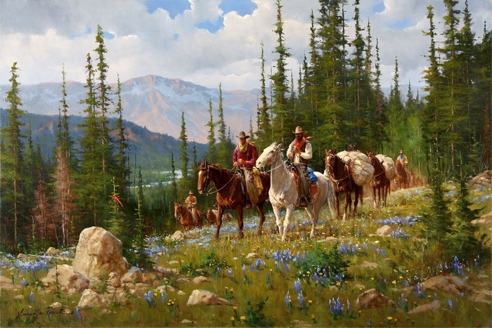 Cowboys on horseback with pack mules in a mountain forest