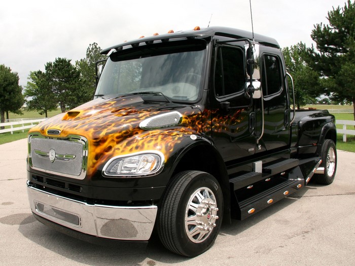 Black Freightliner truck with flame graphics
