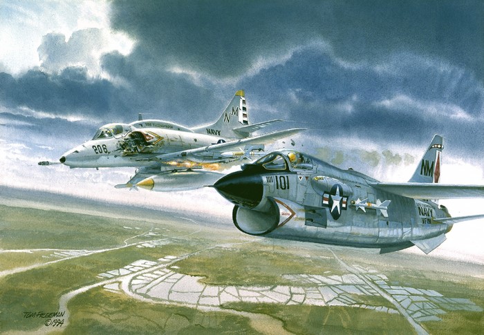 Two Navy fighter jets flying over a landscape