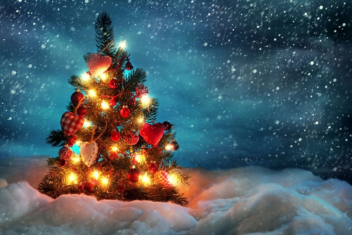 Christmas tree with lights and ornaments in snow