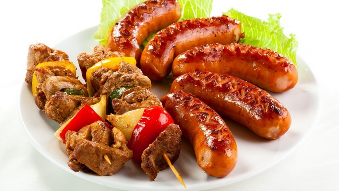 Grilled sausages and meat skewers with vegetables