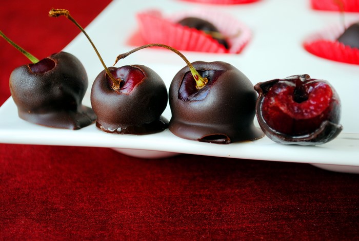 Chocolate covered cherries on a white plate