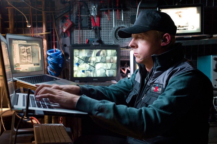 Man in black cap working on laptops in Mission: Impossible