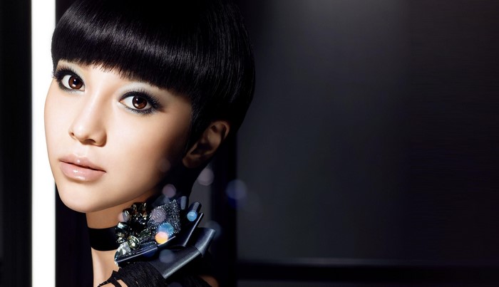 Asian woman with short black hair and dramatic makeup
