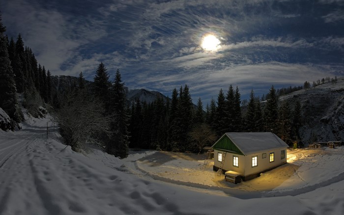 Winter night scene with a house in the snow