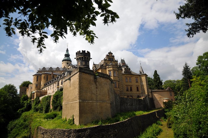 Castle on a hill with trees and clouds