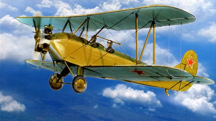 Yellow biplane with red stars flying in the sky