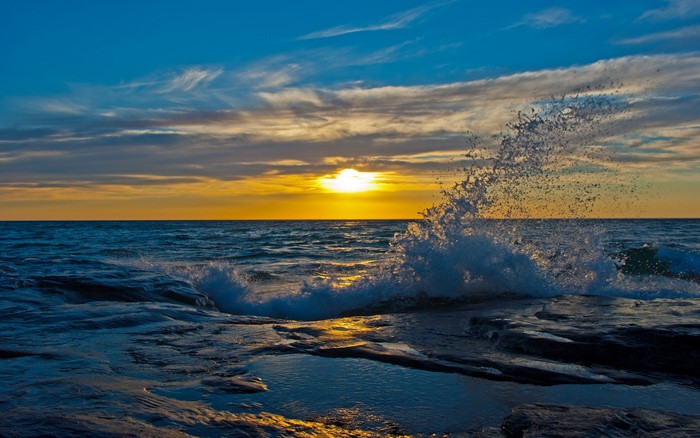Sunset over the ocean with crashing waves