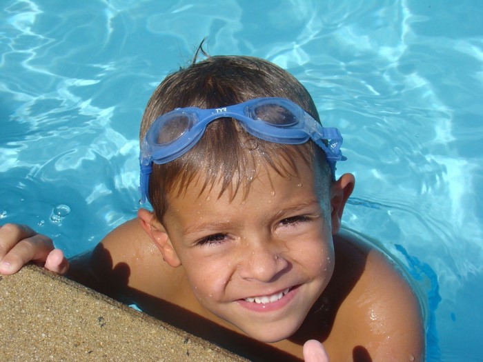 Boy with goggles in a swimming pool