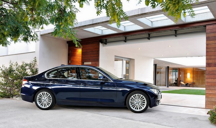 BMW sedan parked in front of a modern house