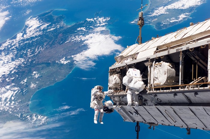 Astronauts performing spacewalk outside the International Space Station