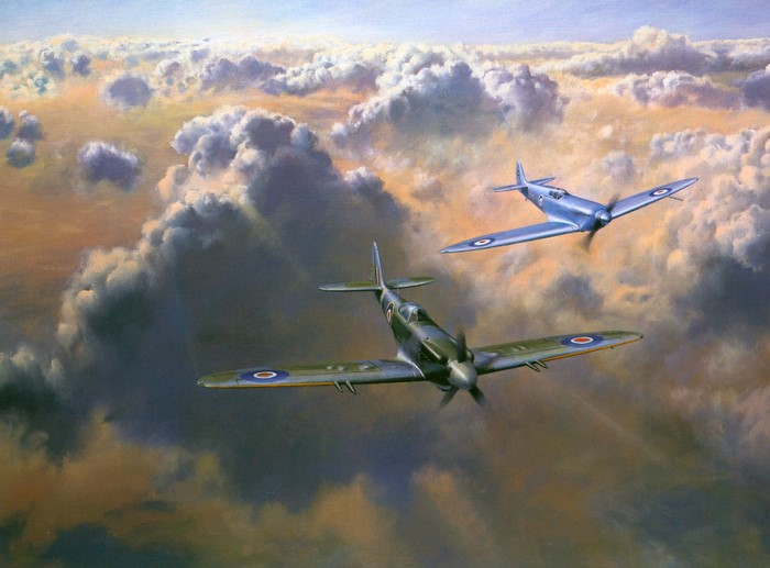 Two Spitfire airplanes flying through clouds