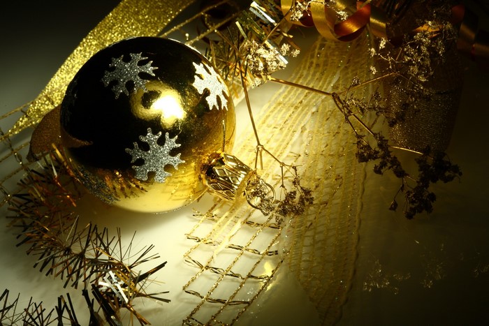 Golden Christmas ornament with snowflakes and ribbons