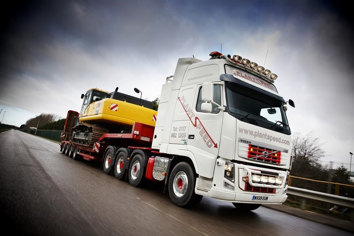 Volvo truck transporting excavator on a trailer