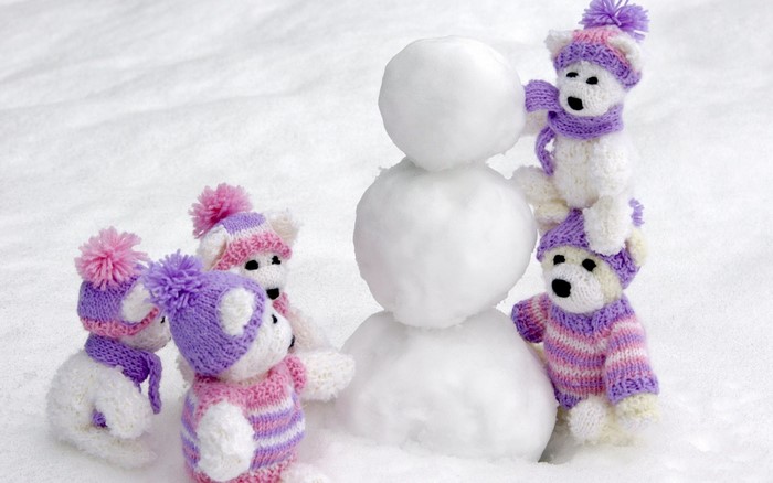 Knitted polar bears building a snowman