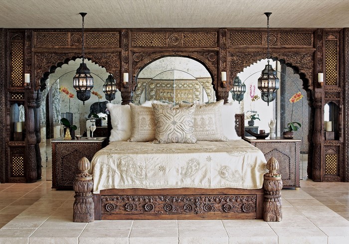 Ornate wooden bed with intricate carvings and hanging lanterns