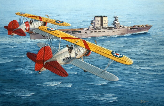 Two biplanes fly over the ocean near an aircraft carrier.