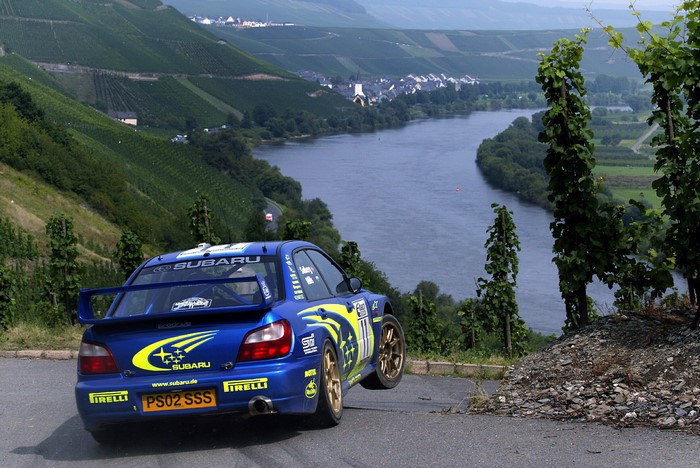 Blue Subaru rally car on a winding road
