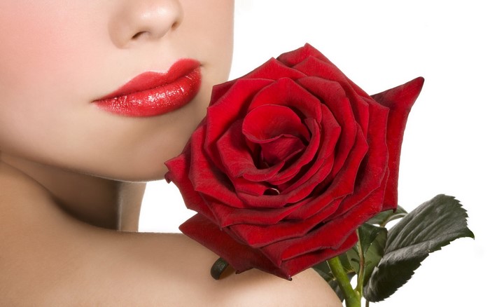 Woman with red lips holding a red rose
