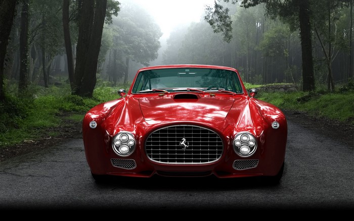 Red vintage Ferrari car on a forest road
