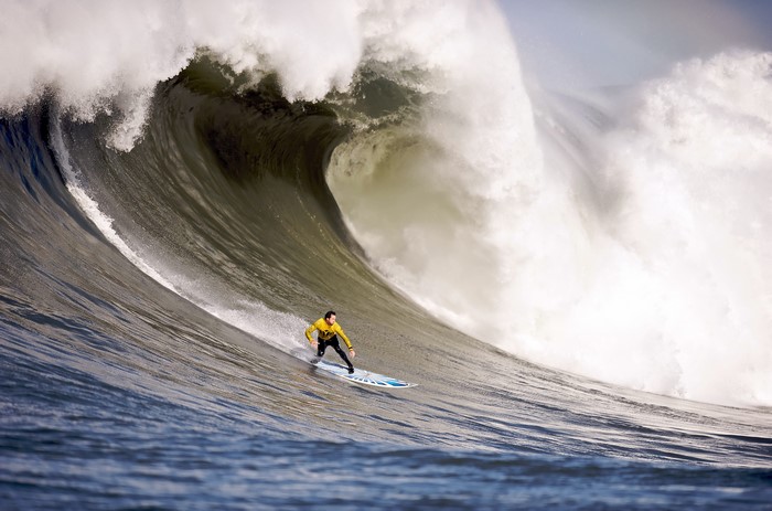 Surfer riding a massive wave