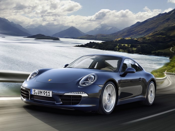 Blue Porsche 911 driving on a scenic road