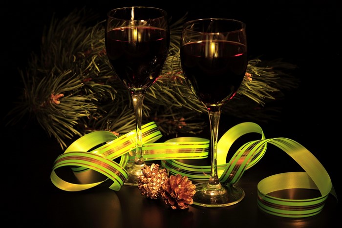 Two glasses of red wine with pine branches and ribbon