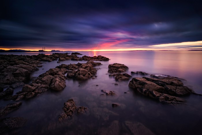 Rocky coastline at sunset with colorful sky
